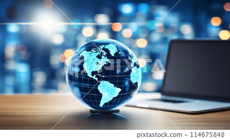 On a wooden table sits a globe next to a laptop computer 114675848