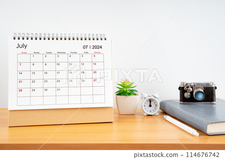 Desktop Calendar for July 2024 year and vintage camera with diary for Planner to plan timetable. 114676742