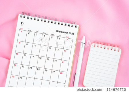 September 2024 month calendar and pen with open diary on pink fabric background. September 2024 month calendar and pen with open diary on pink fabric background. 114676750