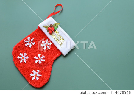 red wool winter sock on green background, christmas decoration 114678546