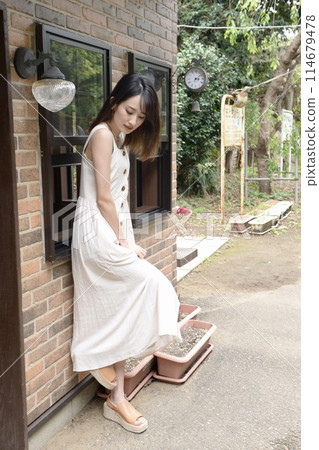 一位身著連體泳衣的年輕女子和當地火車站的站台 114679478