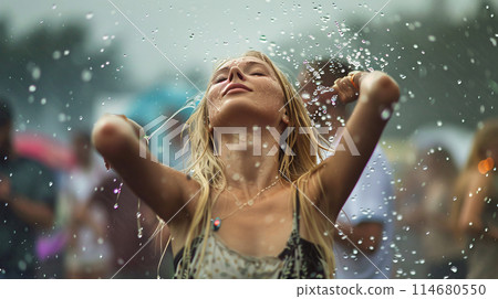summer music festival-goer dancing in the rain at a summer music festival 114680550