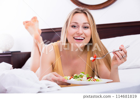 Woman in lingerie having a salad 114681819