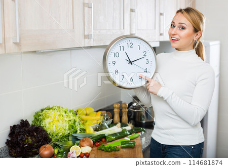 Portrait of positive woman holding clocks Portrait of positive woman holding clocks 114681874