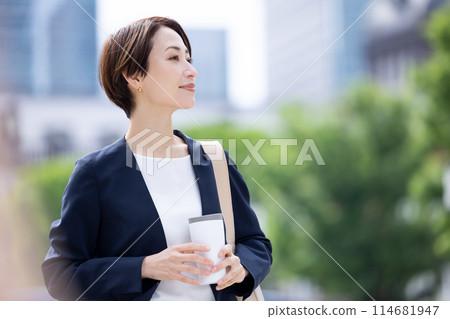 Business woman: A woman walking with a tumbler Business woman: A woman walking with a tumbler 114681947