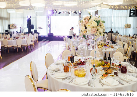 Wedding. Banquet. The chairs and round table for guests, served with cutlery. 114683616