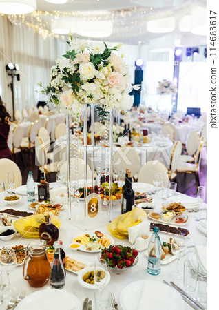 Wedding. Banquet. The chairs and round table for guests, served with cutlery. Wedding. Banquet. The chairs and round table for guests, served with cutlery. 114683617