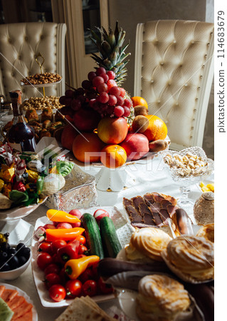 A large variety of fruits and vegetables on the table for guests A large variety of fruits and vegetables on the table for guests 114683679