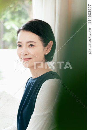 Middle woman sitting on the couch Middle woman sitting on the couch 114683997