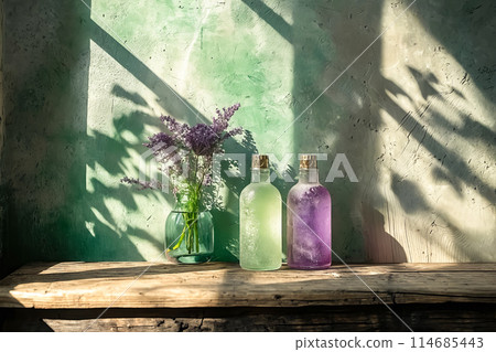Two vases of flowers sit on a wooden table, one of which is purple 114685443