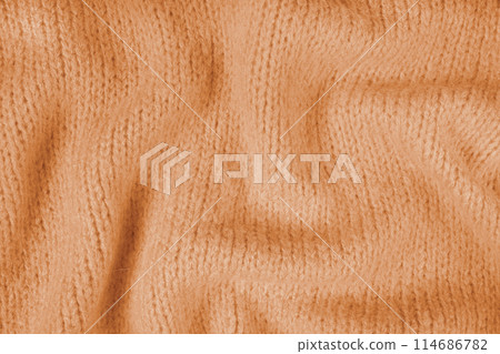 Close up background of orange knitted fabric made of viscose yarn, soft background Close up background of orange knitted fabric made of viscose yarn, soft background 114686782