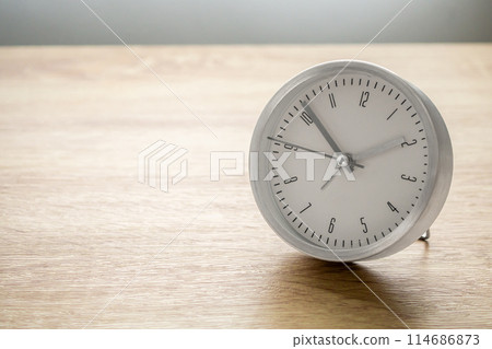 Silver alarm clock on wood table background Silver alarm clock on wood table background 114686873