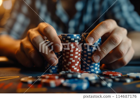 Hands organize blue and red poker chips in a tense casino setting 114687176