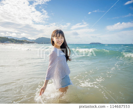 年輕女子在度假村海灘上散步 年輕女子在度假村海灘上散步 114687553