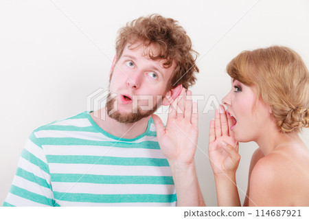 Woman telling an astonished man some secrets Woman telling an astonished man some secrets 114687921