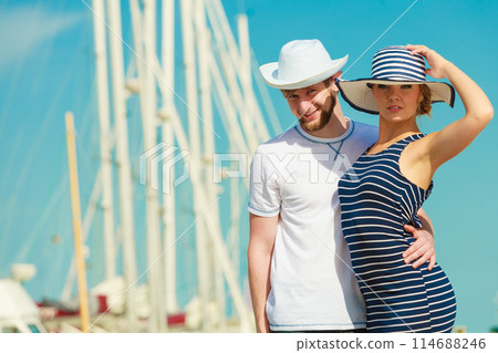 Tourist couple in marina against yachts in port 114688246