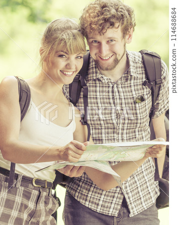 Hiking backpacking couple reading map on trip. Hiking backpacking couple reading map on trip. 114688684