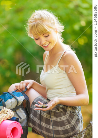 young woman with backpack hiking in forest trail young woman with backpack hiking in forest trail 114688696