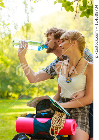 couple hikers resting in forest drinking water couple hikers resting in forest drinking water 114688734
