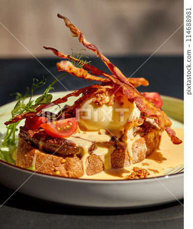 Savory Mediterranean bruschetta with veal steak, bacon, poached egg and sauce Savory Mediterranean bruschetta with veal steak, bacon, poached egg and sauce 114688981