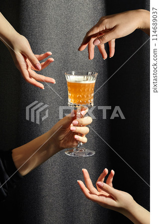 Female hands hovering around crystal glass of whiskey sour 114689037