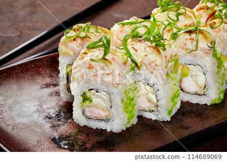 Uramaki sushi rolls with green tobiko, crab and creamy sauce Uramaki sushi rolls with green tobiko, crab and creamy sauce 114689069
