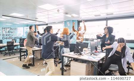 Cheerful businesspeople reaching for currency notes thrown by managers at office Cheerful businesspeople reaching for currency notes thrown by managers at office 114690727