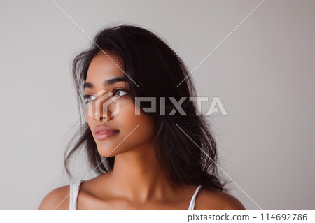 Beautiful young Indian woman takes care of her skin, posing over grey background 114692786