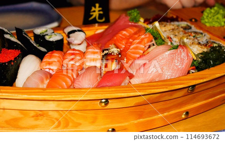 Japanese sushi and sashimi set served on a wooden boat 114693672