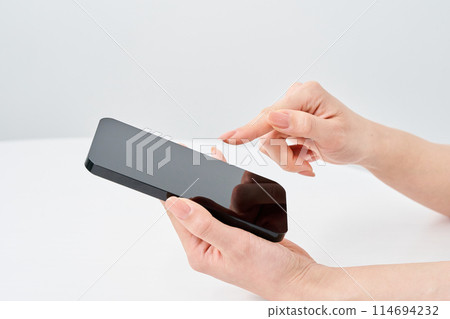 Hand of a woman who operates a smartphone 114694232