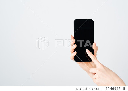 Hand of a woman who operates a smartphone 114694246