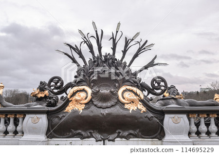 Backside of Nymphes de la Seine sculpture of the downstream parapet of the Alexander III Bridge (Pont Alexandre III) with sky background in Paris. Backside of Nymphes de la Seine sculpture of the downstream parapet of the Alexander III Bridge (Pont Alexandre III) with sky background in Paris. 114695229
