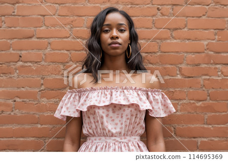 Afroamerican Woman Standing in Front of Brick Wall Afroamerican Woman Standing in Front of Brick Wall 114695369