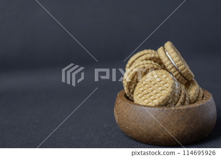 Cream biscuit on black background Cream biscuit on black background 114695926