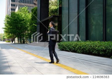 A businessman in a suit commuting to work A businessman in a suit commuting to work 114696363