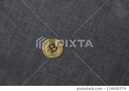 Bitcoin on blue fabric background, physical version of the main gold cryptocurrency, concept of investing and saving money in electronic money Bitcoin on blue fabric background, physical version of the main gold cryptocurrency, concept of investing and saving money in electronic money 114698374