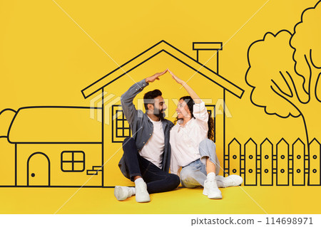 Diverse man and a woman couple are sitting on the ground in front of a house. They appear relaxed and engaged in conversation, with the house as a backdrop. Diverse man and a woman couple are sitting on the ground in front of a house. They appear relaxed and engaged in conversation, with the house as a backdrop. 114698971