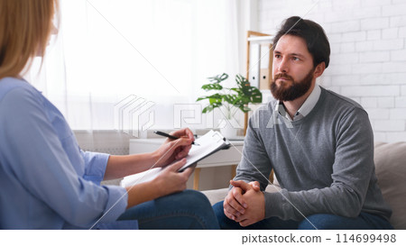 At psychotherapist. Millennial man talking to specialist at therapy session, free space 114699498