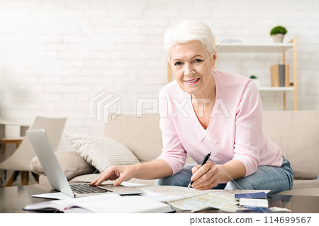 Active senior lady planning trip, choosing travel route on map at home, free space Active senior lady planning trip, choosing travel route on map at home, free space 114699567