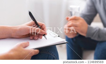 Psychologist taking notes during session with depressed patient, close up, panorama 114699569