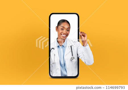 Young black woman doctor appears inside a smartphone for online consultations, exemplifying modern medicine, showing medicine pill 114699793