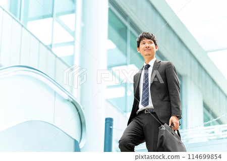 Male businessman walking in an office district 114699854