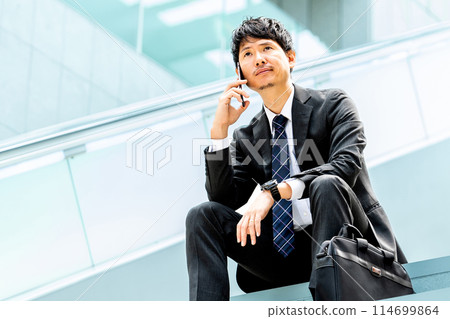 男性商人在智慧型手機上交談 男性商人在智慧型手機上交談 114699864