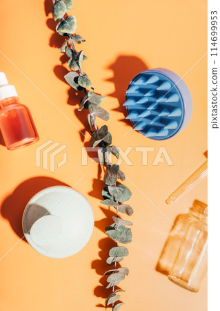 Massagers for scalp and glass jars with serum on a yellow background 114699953
