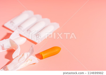Rectal candles in packaging and unpacked on a pink background Rectal candles in packaging and unpacked on a pink background 114699982