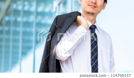 Male businessman putting his jacket over his shoulder 114700337
