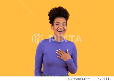 Hispanic woman wearing a purple shirt is smiling happily. Her expression exudes joy and contentment, showcasing a moment of happiness captured in a candid shot. Hispanic woman wearing a purple shirt is smiling happily. Her expression exudes joy and contentment, showcasing a moment of happiness captured in a candid shot. 114701119