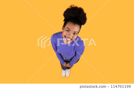 Top view of Hispanic woman standing with a purple shirt and white socks. She appears casual and comfortable in her attire. Top view of Hispanic woman standing with a purple shirt and white socks. She appears casual and comfortable in her attire. 114701199
