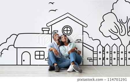 Loving African American couple planning their dream home against a hand-drawn house sketch on white wall background. Mortgage concept Loving African American couple planning their dream home against a hand-drawn house sketch on white wall background. Mortgage concept 114701291