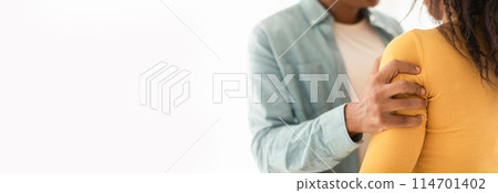 Closeup of a black man's hand providing comfort to a woman with a gentle touch, ample copy space to the left for web-banner use Closeup of a black man's hand providing comfort to a woman with a gentle touch, ample copy space to the left for web-banner use 114701402